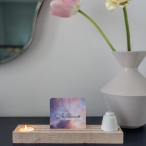 Houten plankje met daarin een waxinelichtje en een klein urntje. In het midden van het plankje is er ruimte voor een foto of een kaartje.