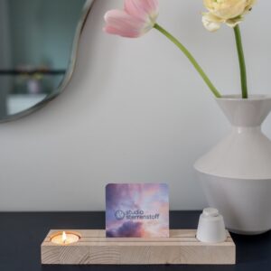 Houten plankje met daarin een waxinelichtje en een klein urntje. In het midden van het plankje is er ruimte voor een foto of een kaartje.