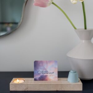 houtenplankje met daarin een klein keramiek urntje en waxinelichtje.in het midden van het plankje is er ruimte voor een kaart of een foto.