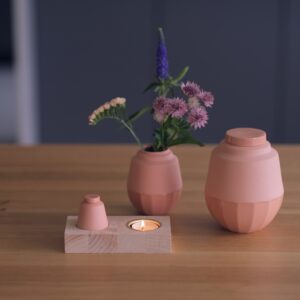 houtenplankje met daarin een klein keramiek urntje en waxinelichtje.