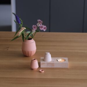 houtenplankje met daarin een klein keramiek urntje en waxinelichtje.