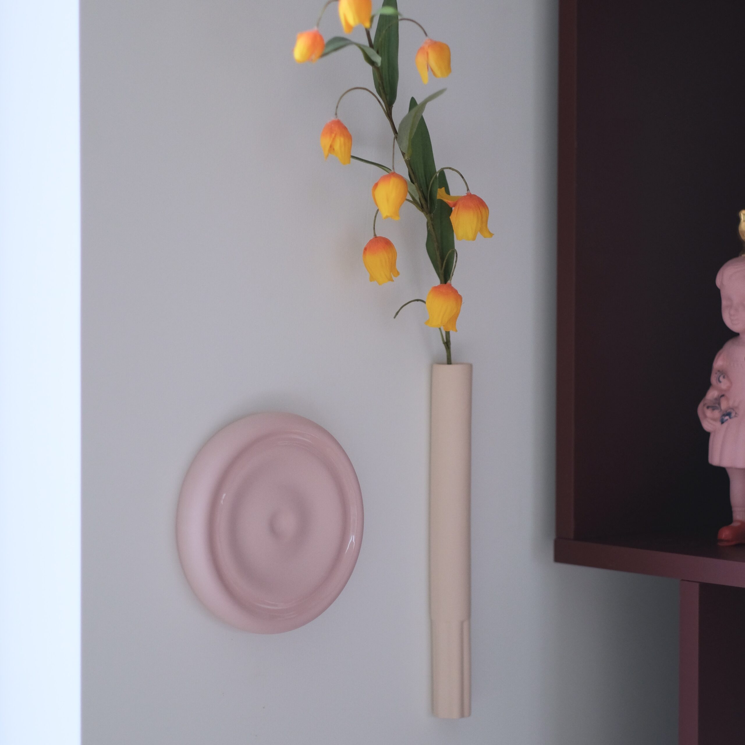 ronde urn voor aan de wand. Strak en organische design.