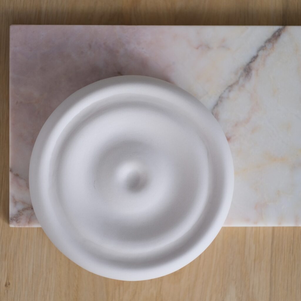ronde urn voor aan de wand. Strak en organische design.