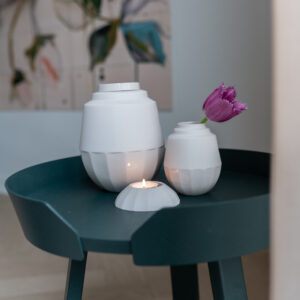 Urn met vaasje en waxinelichthouder op een tafel